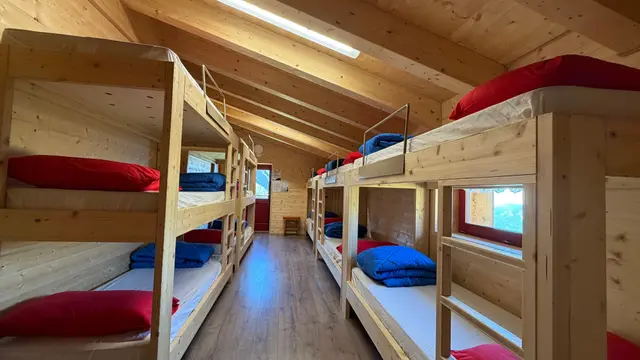 Camerata con letti a castello in legno e vista sulle vette